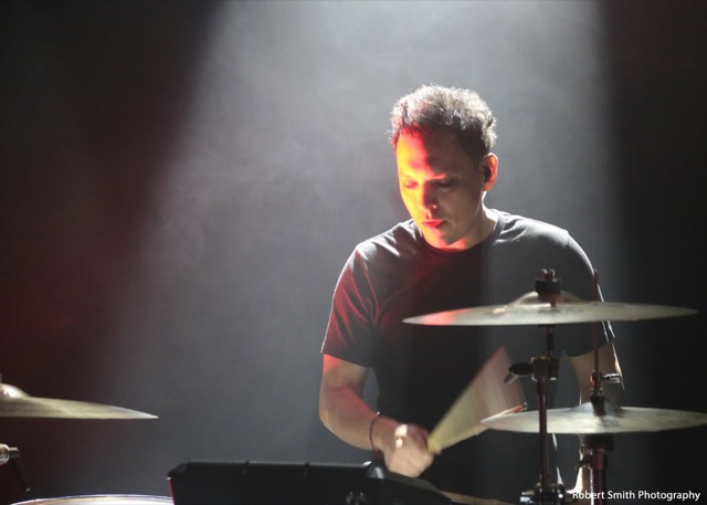 Sonny Sanchez drumming in a spotlight